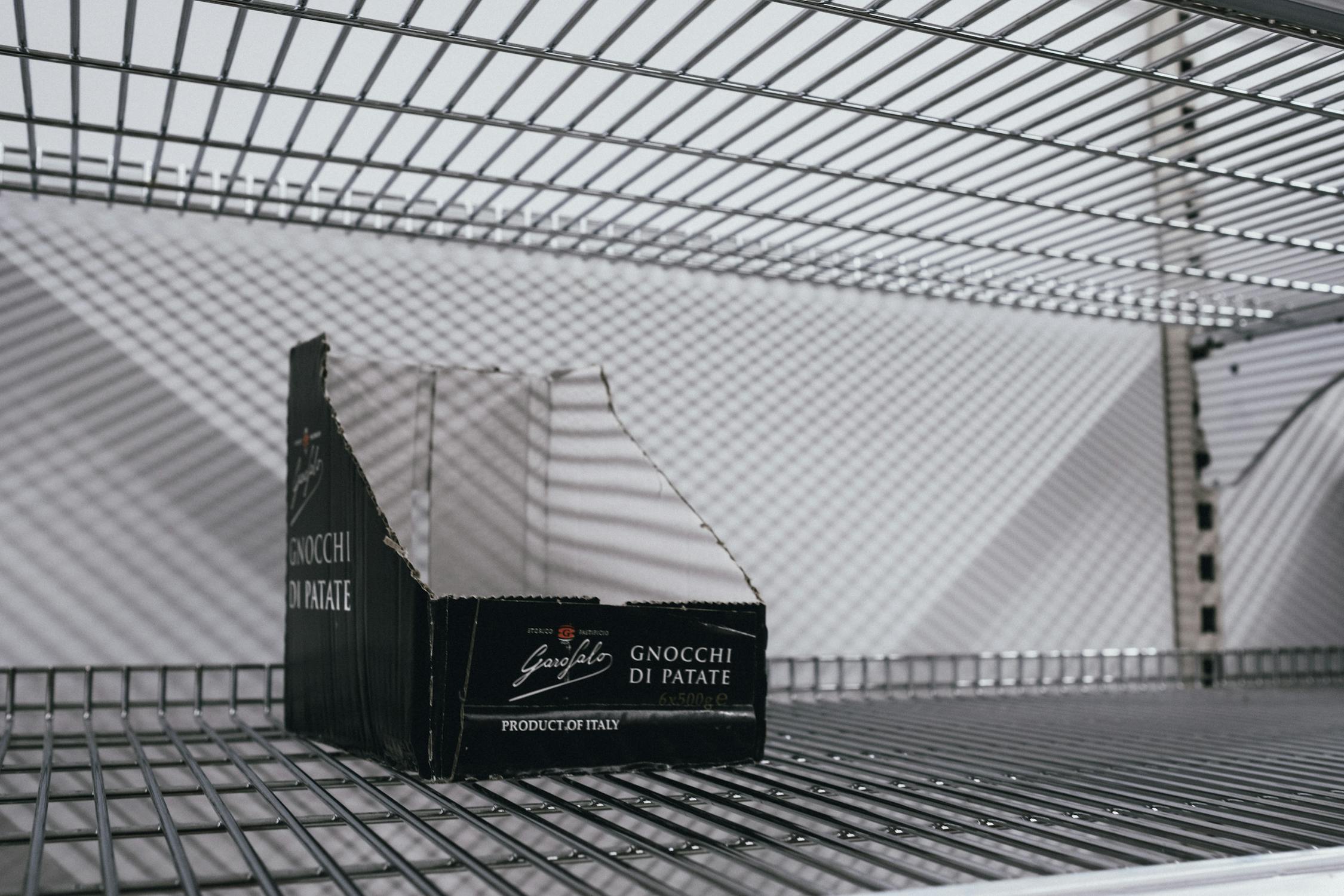 Empty box on a grocery shelf illustrating stockout and inventory management